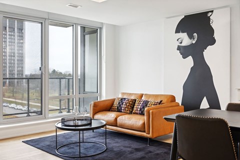 Modern living room with orange leather sofa at Petries Landing II Apartments, Ottawa, Ontario