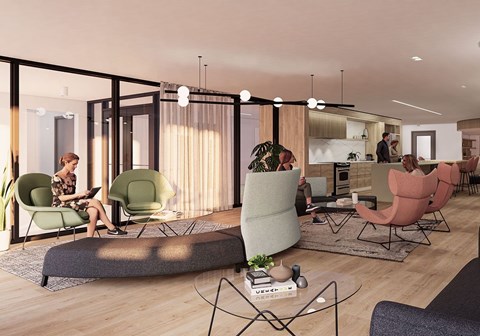 A woman is sitting on a green chair in a modern living room.
