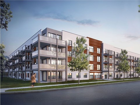 A modern apartment building with a person walking in front.