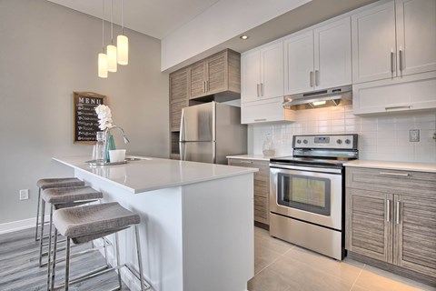 A modern kitchen with a white island and stainless steel appliances.