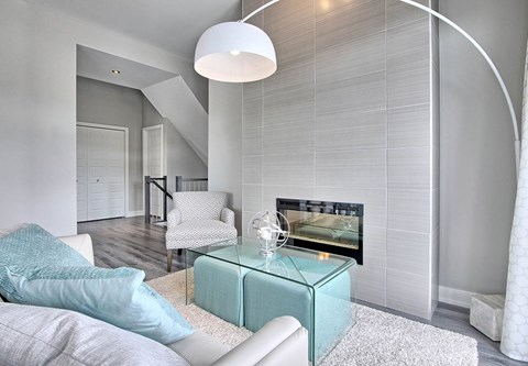 A modern living room with a white couch and a glass coffee table.