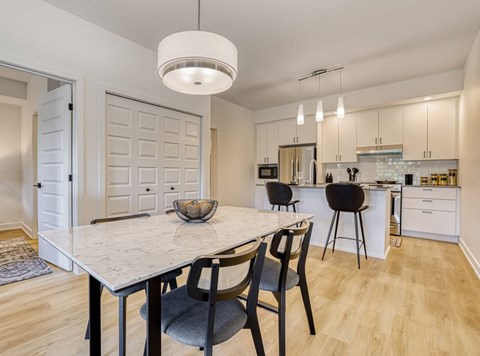 A modern kitchen with a dining table and chairs.
