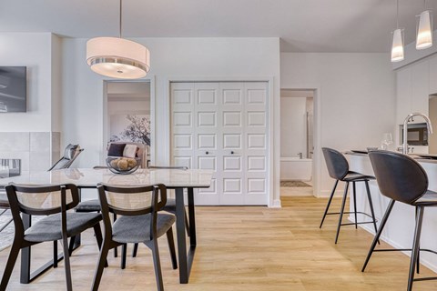 A modern dining room with a white door and a table set for four.