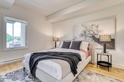 A bedroom with a large bed and a painting on the wall.