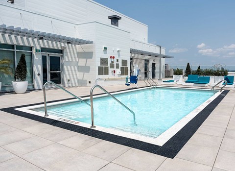 Rooftop swimming pool with deck furniture at Baseline Apartments, Ottawa