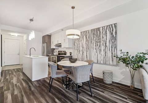 A modern kitchen with a dining table and chairs.