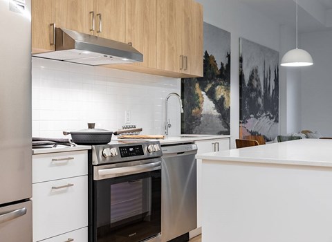 A modern kitchen with a stainless steel oven and white countertops.