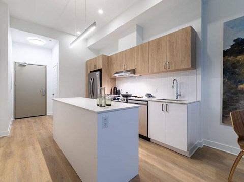 A modern kitchen with wooden cabinets and a white island.