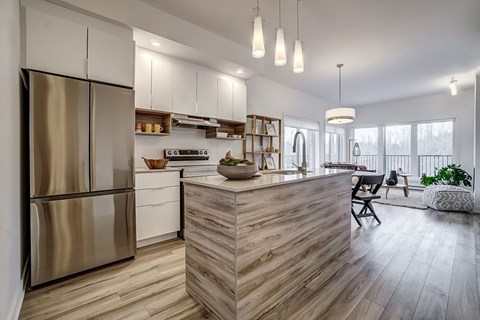 A modern kitchen with a wooden island and stainless steel appliances.