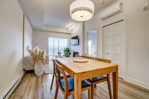 A dining room with a wooden table and chairs.