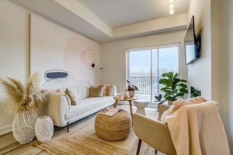 A living room with a white couch and a large window.