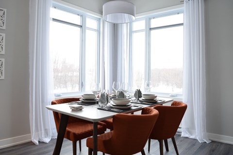 A dining table with four chairs and a white tablecloth is set for a meal.