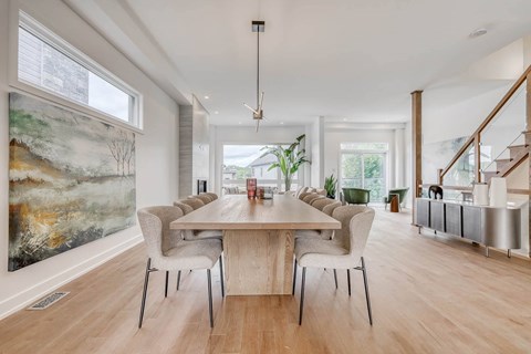 A dining room with a large table and chairs.