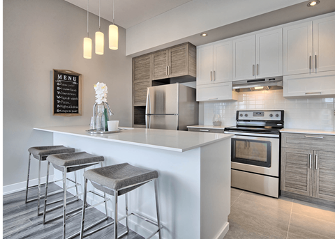 A modern kitchen with a white countertop and stainless steel appliances.