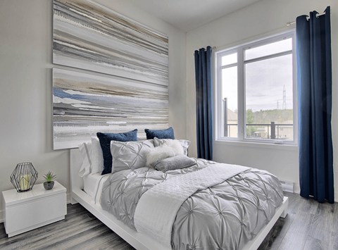A bedroom with a large bed and a large painting on the wall.