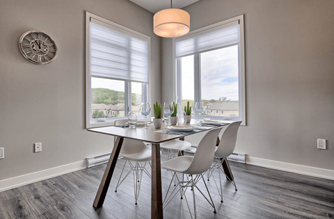 A dining room with a round table and chairs.