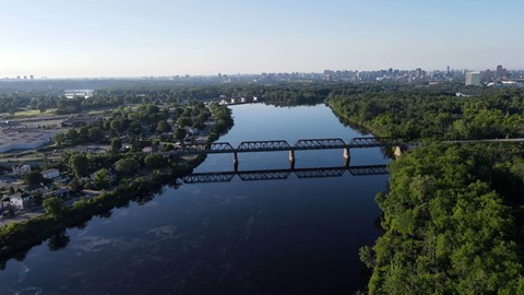A bridge spans a river with a city in the background.