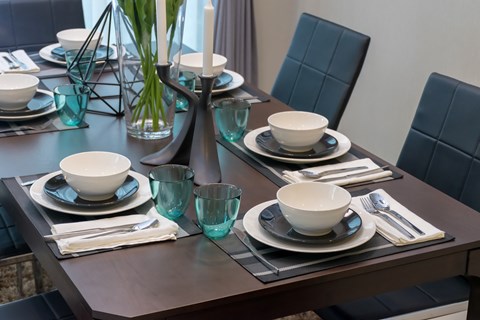 A dining table set with plates, glasses, and cutlery.