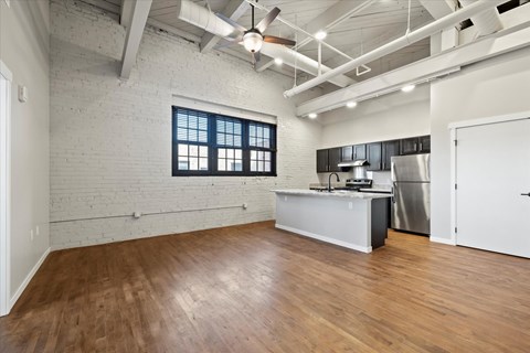 A kitchen area with a stainless steel refrigerator and a countertop with a sink.