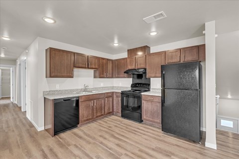 A kitchen with wooden cabinets and black appliances.