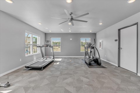 A spacious room with a treadmill and a stationary bike.