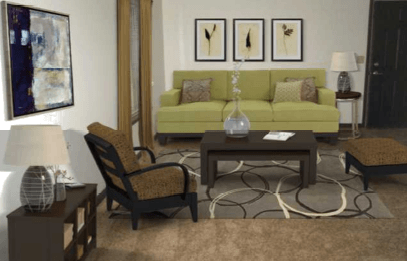 A living room with a green couch, a coffee table, and a chair.
