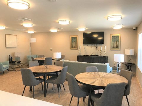 A modern dining room with a round table and grey chairs.