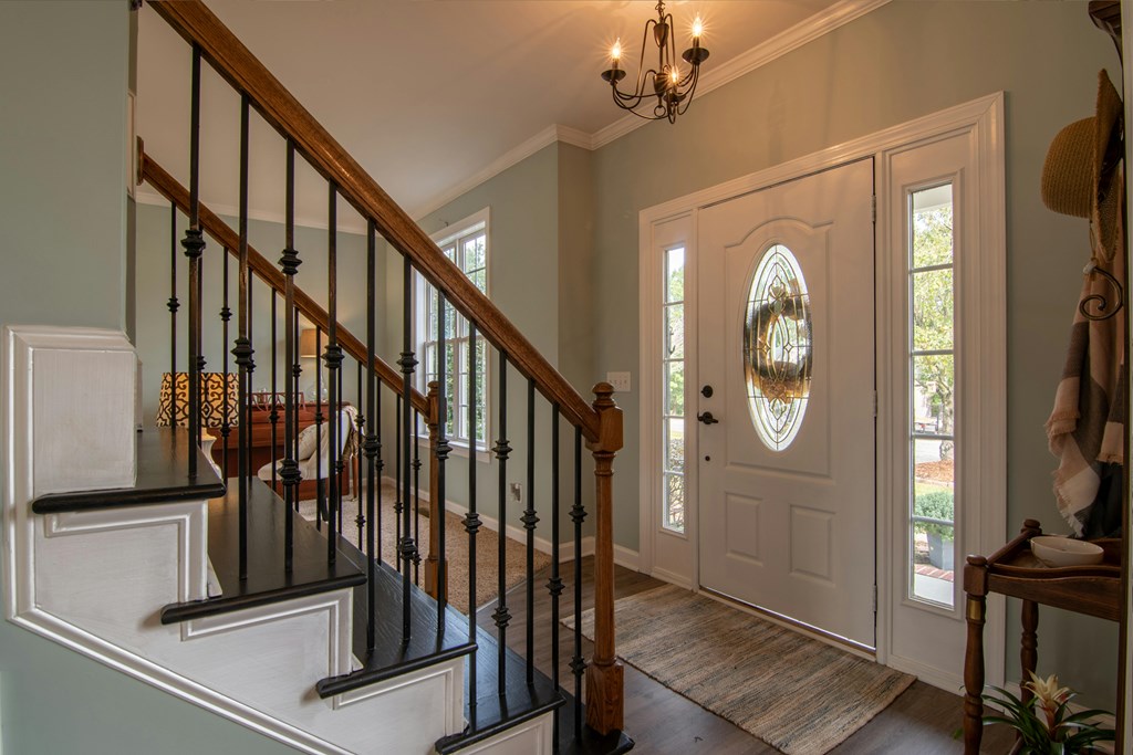 A staircase with a black railing and a light brown carpet.