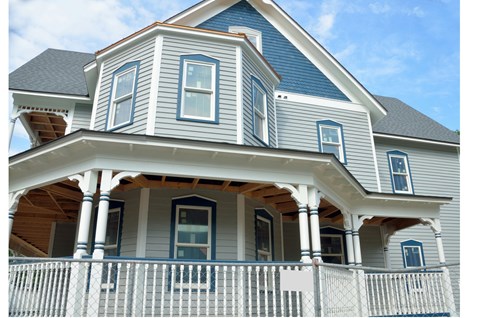 A blue house with white trim and a porch.