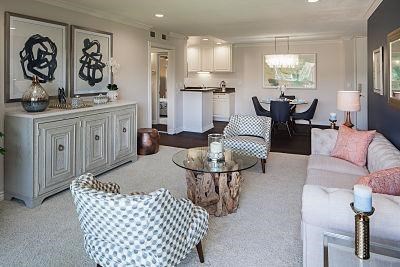 A living room with a checkered chair and a glass coffee table.