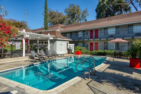 A pool with a slide and a sun shade.