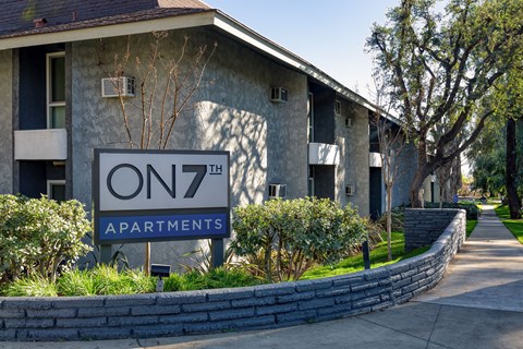Apartment complex with a sign that says "On 7th Apartments"