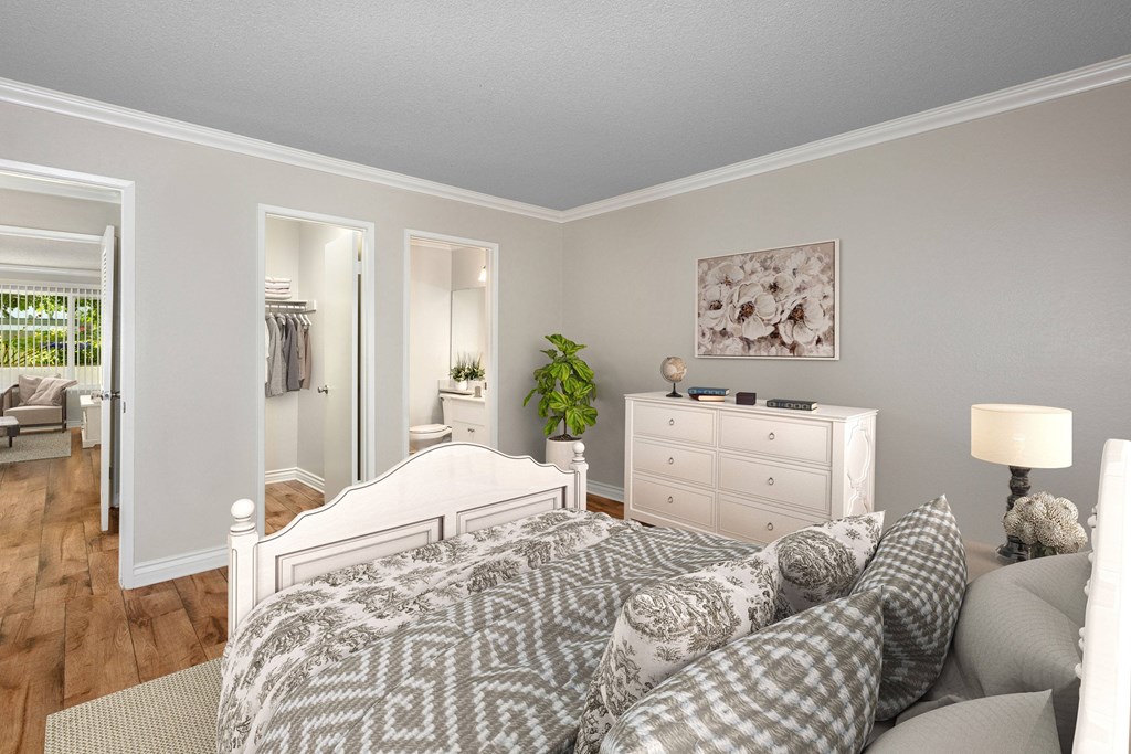A bedroom with a large bed and a white dresser.