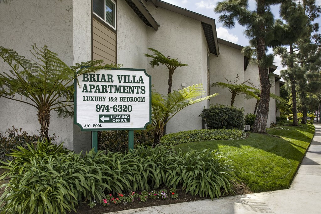 A sign for Briar Villa Apartments is in front of a building.