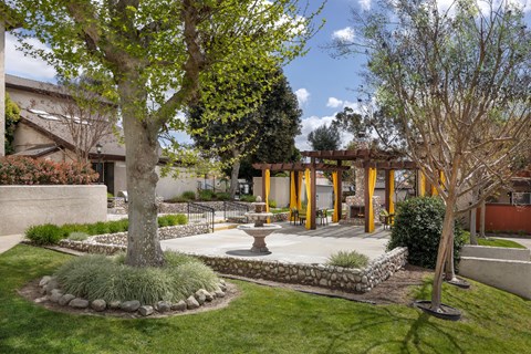 A common area patio with a fireplace and chairs.