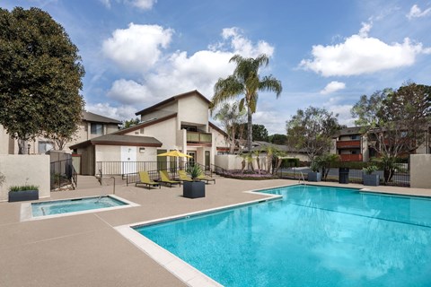 A swimming pool in a residential area surrounded by trees and houses.