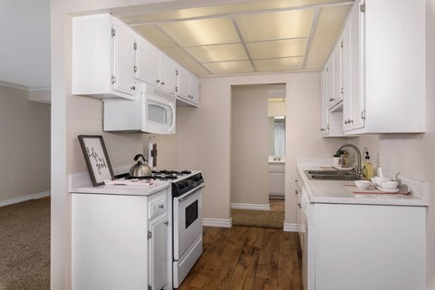 A kitchen with white appliances and cabinets.