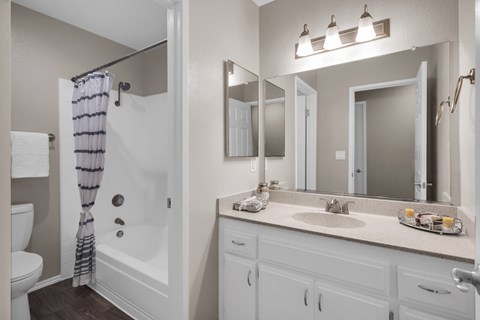 A bathroom with a white sink and a white toilet.