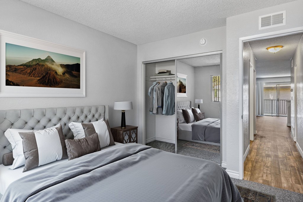 A bedroom with a large bed and a painting of a mountain on the wall.