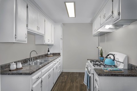 A kitchen with white cabinets and a granite countertop.