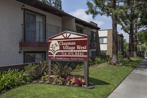 A sign for "Chapman Village West Apartments."