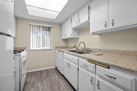 A kitchen with white appliances and cabinets.