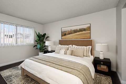 A bedroom with a large bed and a painting on the wall.