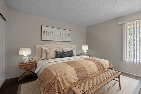 A bedroom with a bed, nightstands, and a bench.
