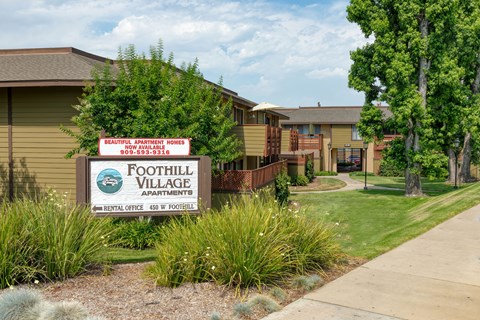 A sign for Foothill Village Apartments is in front of some buildings.