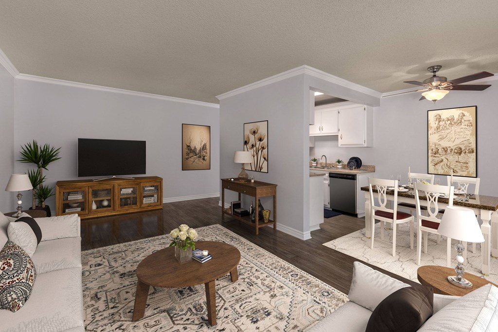 A living room with a white couch, a coffee table, and a television.