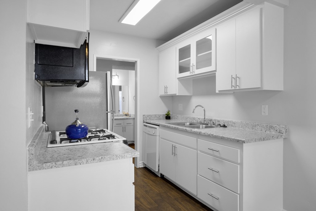 A kitchen with white cabinets and a granite countertop.