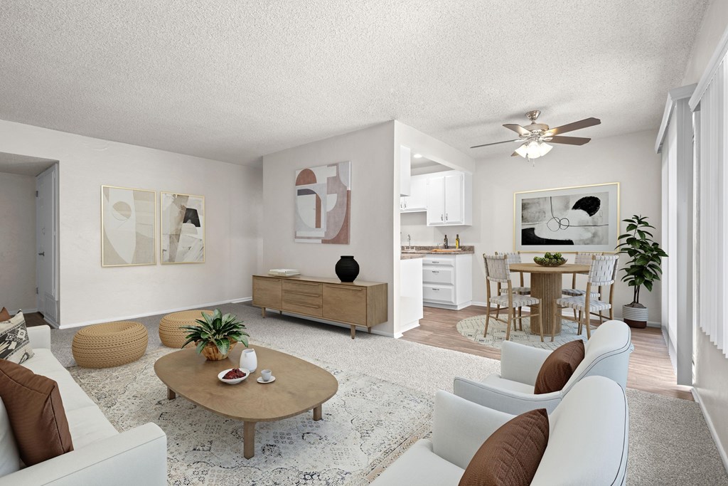 A living room with a white couch, a coffee table, and a ceiling fan.