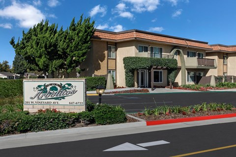 A building with a sign that says Los Arbolitos in front of it.