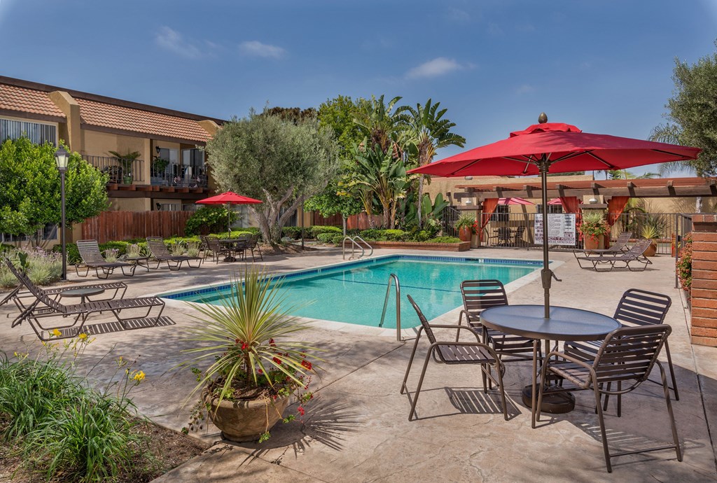 A poolside patio with a table and chairs.